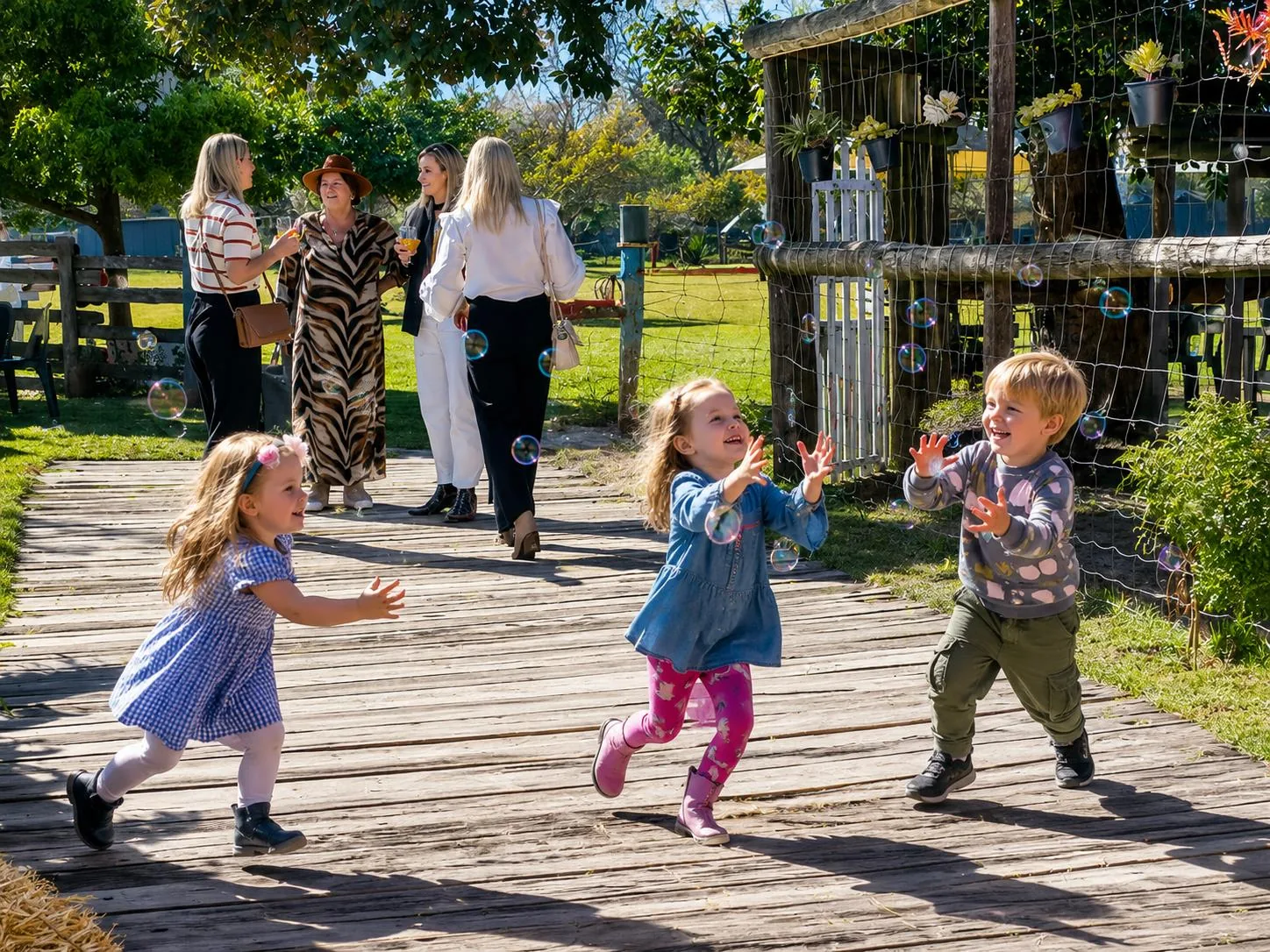 Toddlers chasing bubbles outdoors at Lat Wai